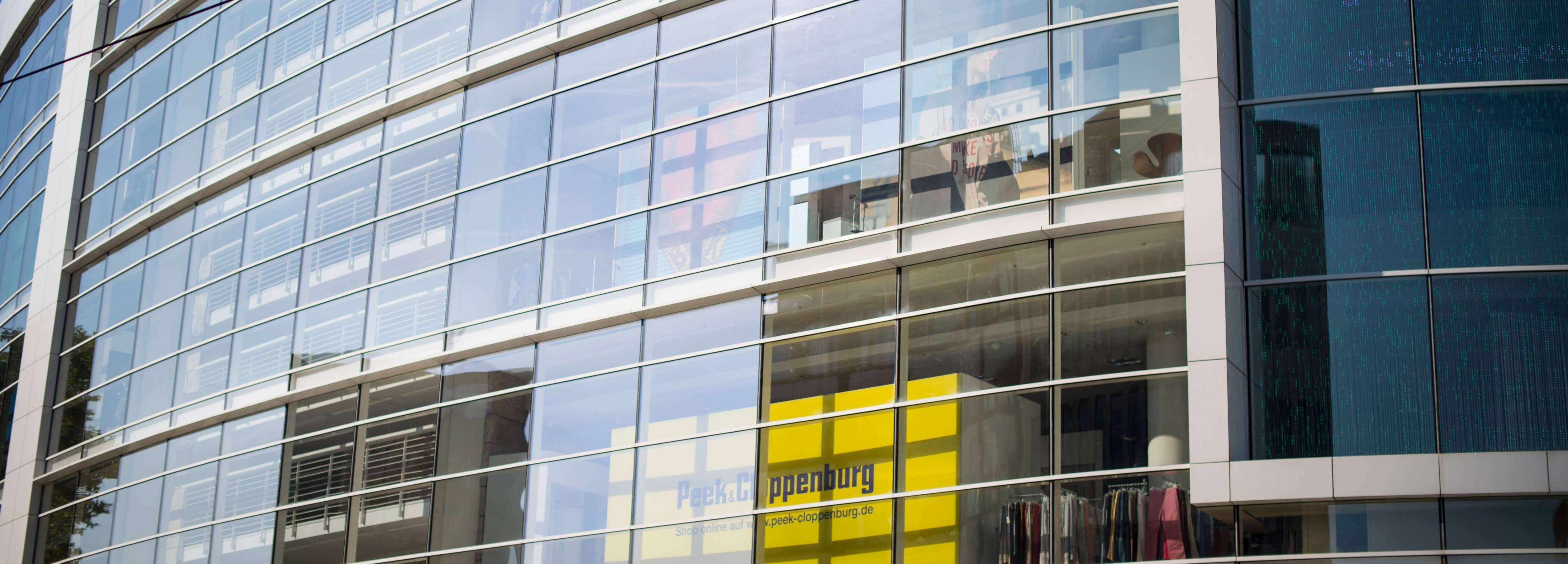 Blick auf die Fassade eines modernen, verglasten P&C Verkaufshauses.